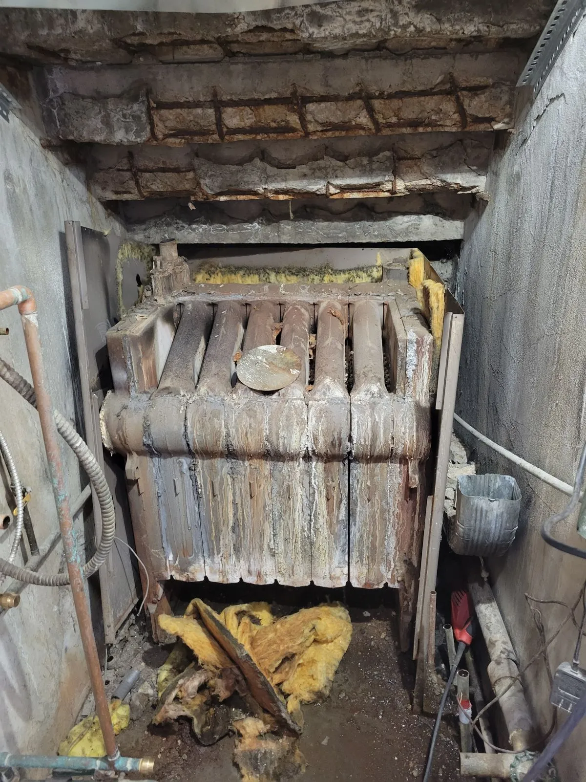 Before: Cast iron boiler in a utility closet