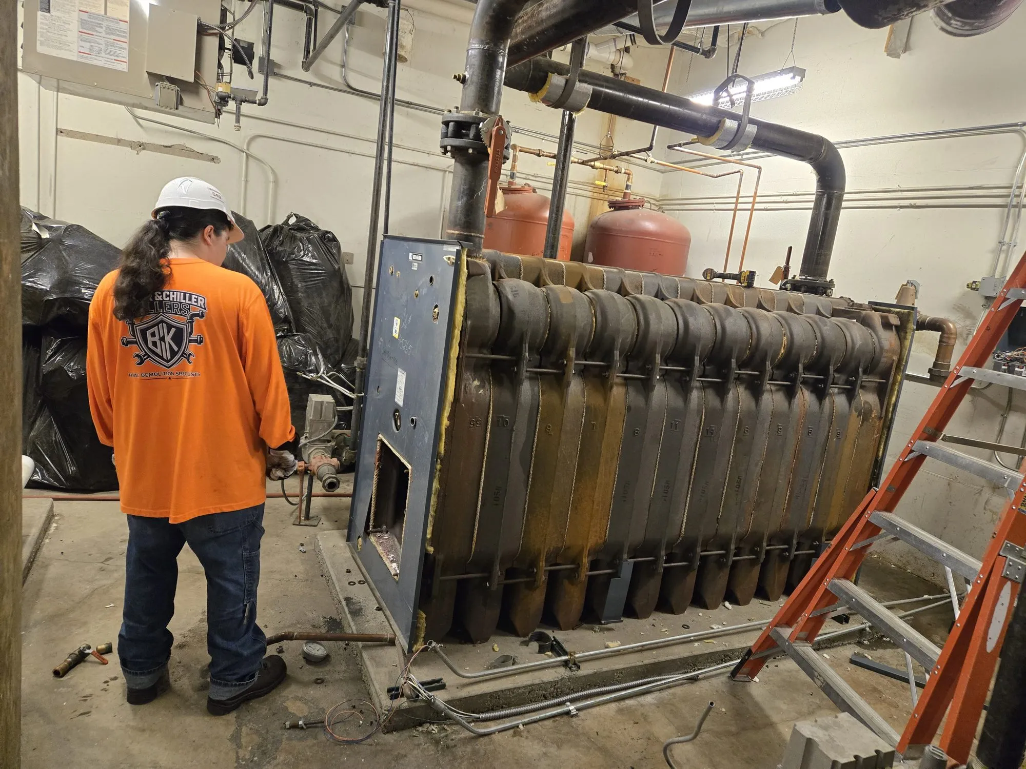 Crew member in a BCK shirt at a cast iron sectional boiler