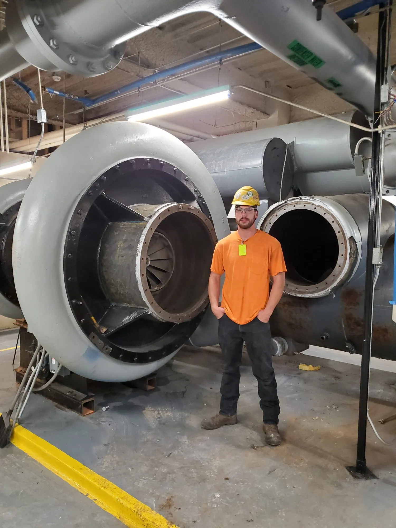 Crew member inside the opened shell of a large chiller during demolition