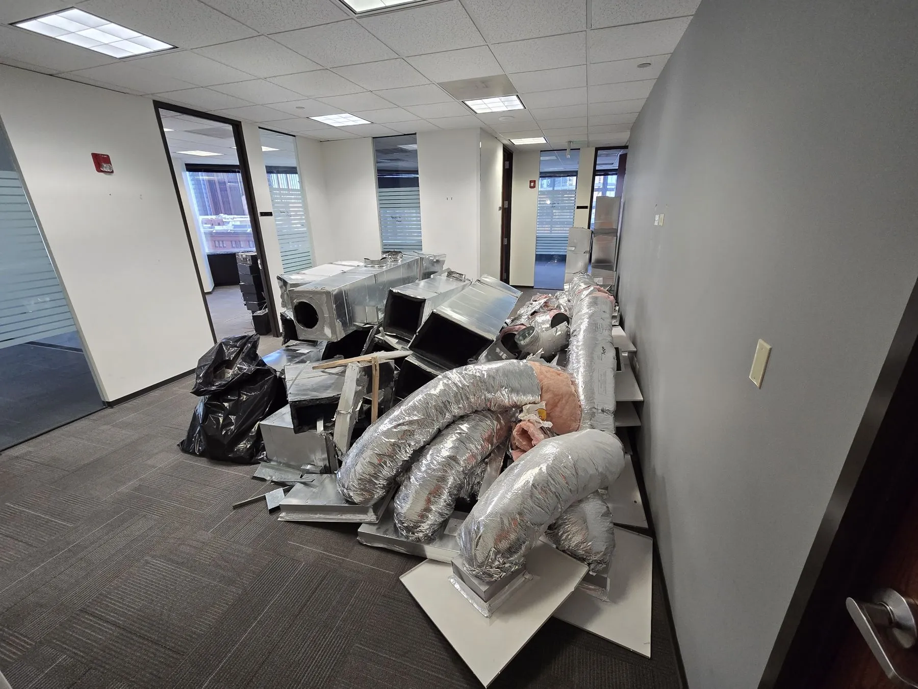 Sectioned HVAC equipment staged on a high-rise floor for haul-out