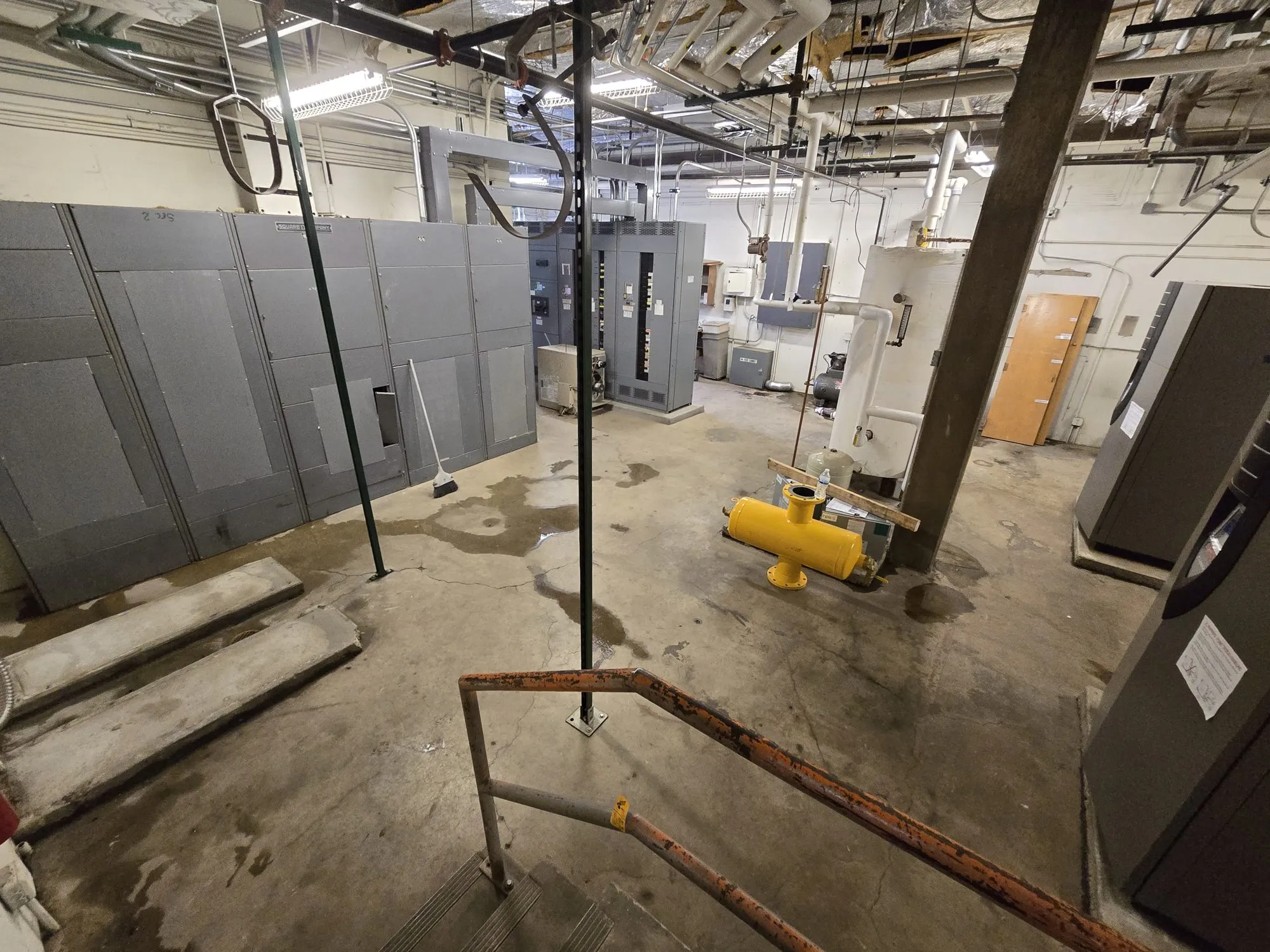 Large mechanical room cleared of equipment with the floor swept clean