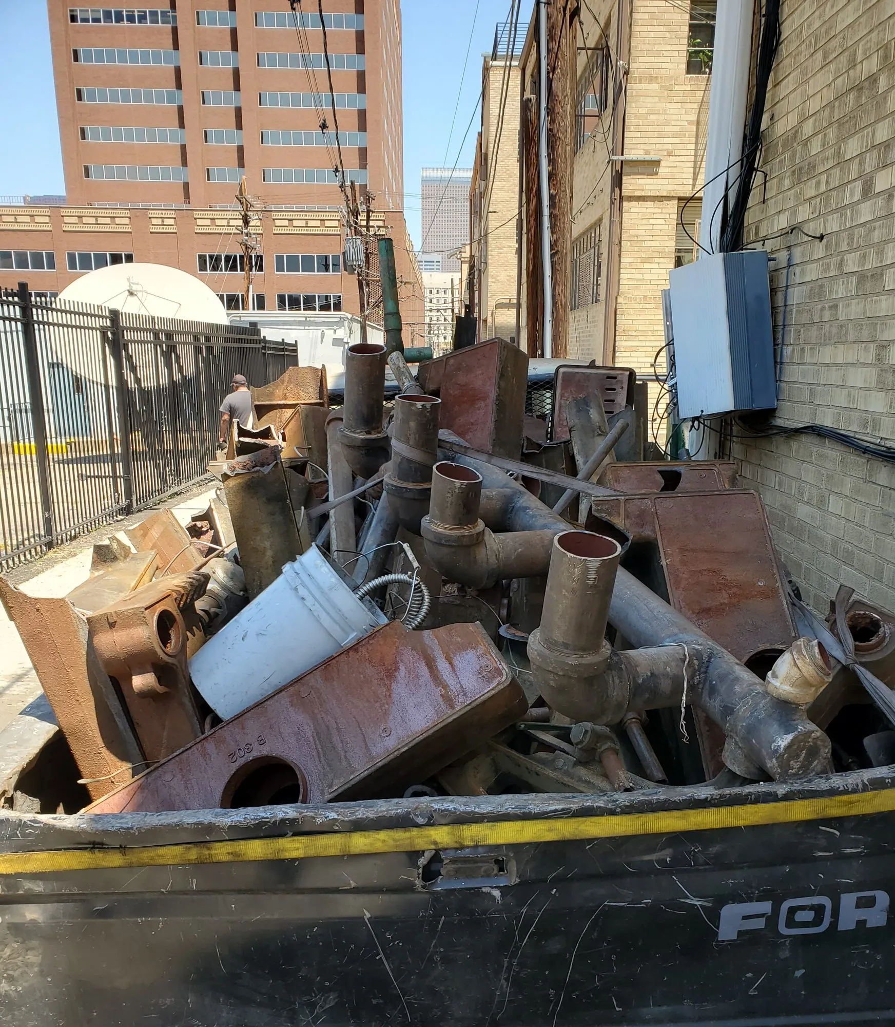 Truck bed loaded with cast iron boiler sections and pipe for haul-out downtown